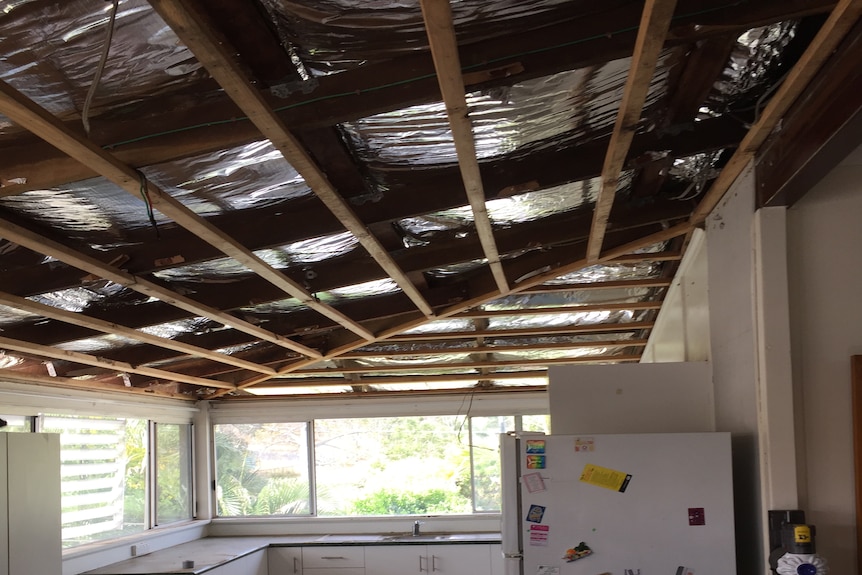 a kitchen area with exposed roof beams and no ceilings 