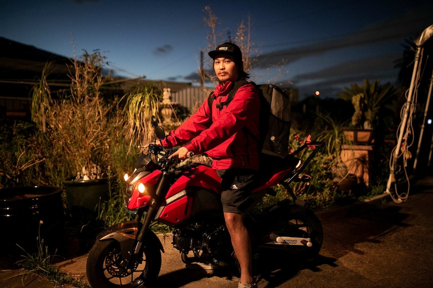 man on motor cycle in the backyard under dim lighting