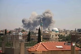 Smoke rising over buildings that were hit by Syrian government forces bombardment in Daraa