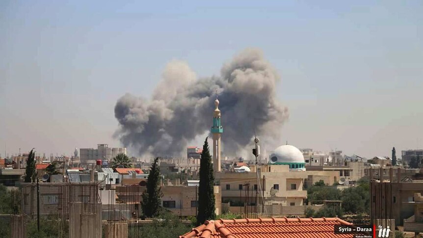 Smoke rising over buildings that were hit by Syrian government forces bombardment in Daraa