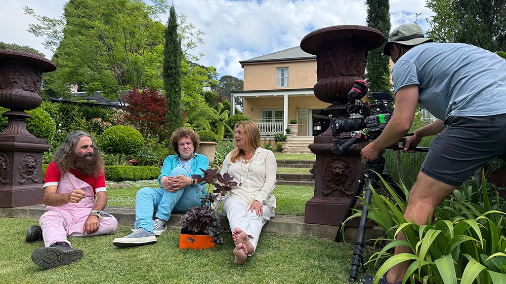 Costa, Leo Sayer and Donatella Piccinetti being filmed in their garden.