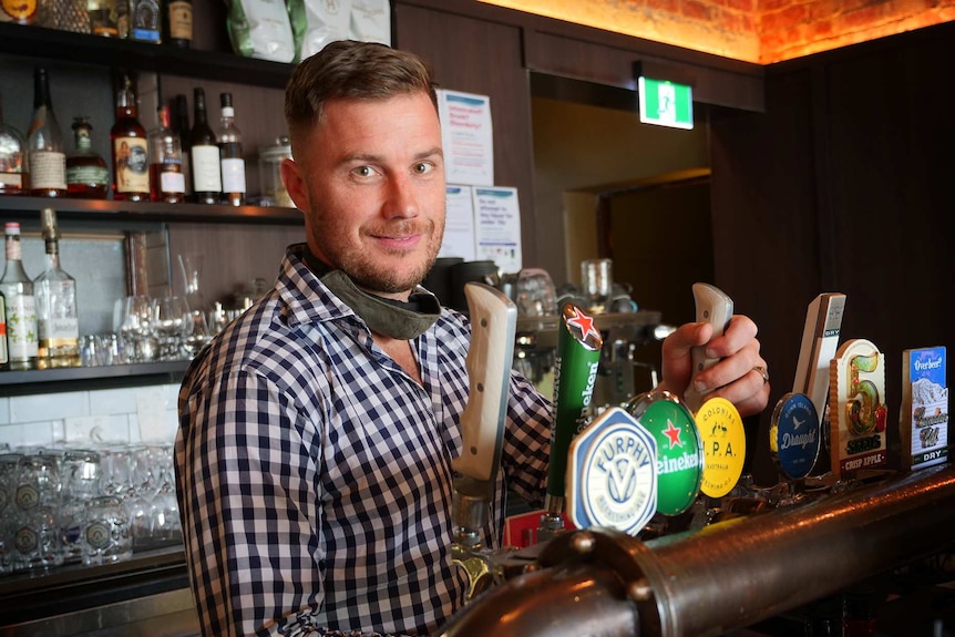 Nick Allardice pours a beer at the bar