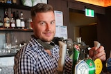 Nick Allardice pours a beer at the bar