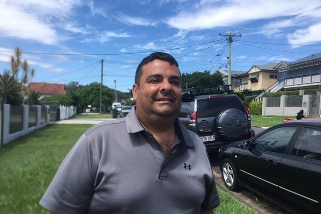 Phil Patane stands in street posing for camera.