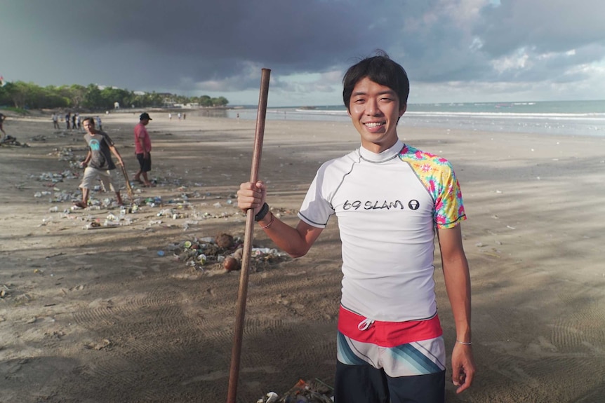 A tourist cleans up garbage on a Bali beach