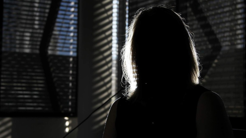 A photo of a woman's silhouette, backlit against an office conference room.