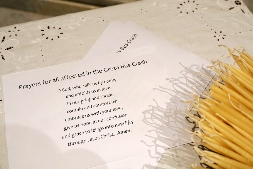 A piece of paper with a prayer written on it for victims of a bus crash.