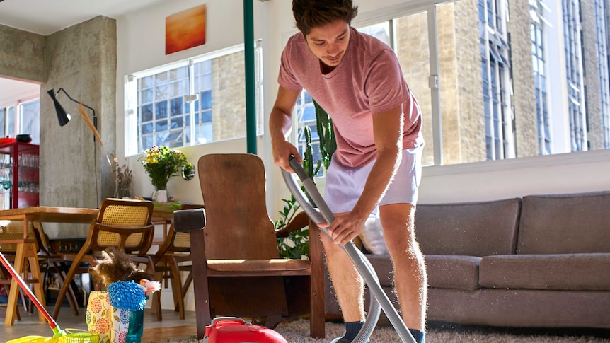 Man in boxer shorts vacuuming the carpet