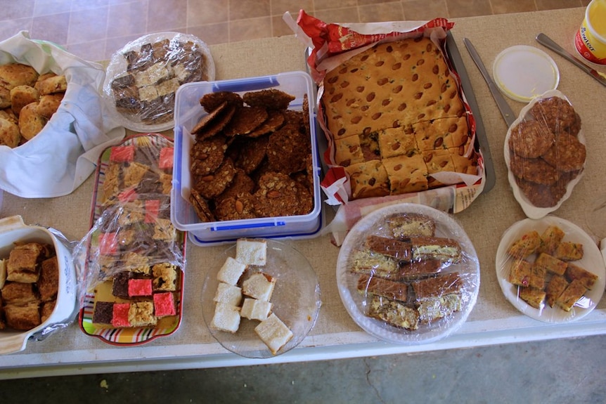Plates of biscuits, cakes, scones and other dishes on a table.