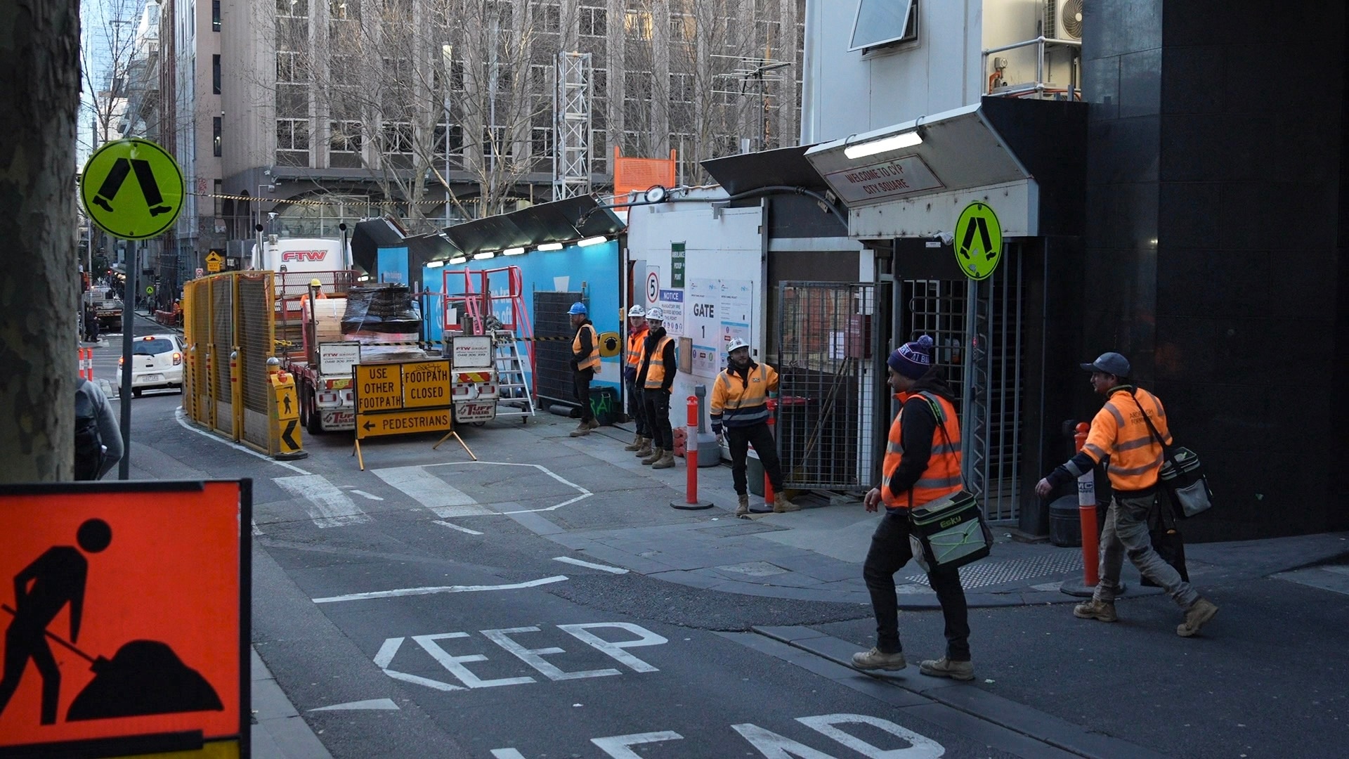 Seis trabalhadores da construção civil usando coletes de alta visibilidade no CBD de Melbourne.