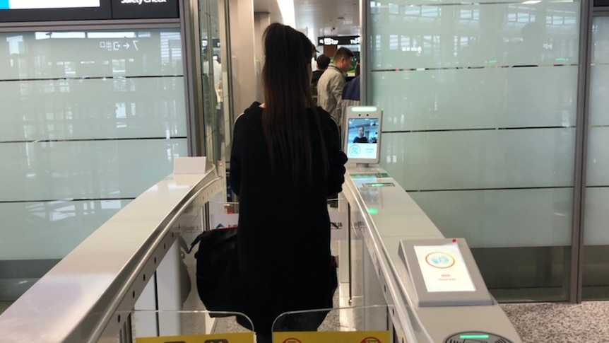 A passenger goes through the facial recognition check-in system