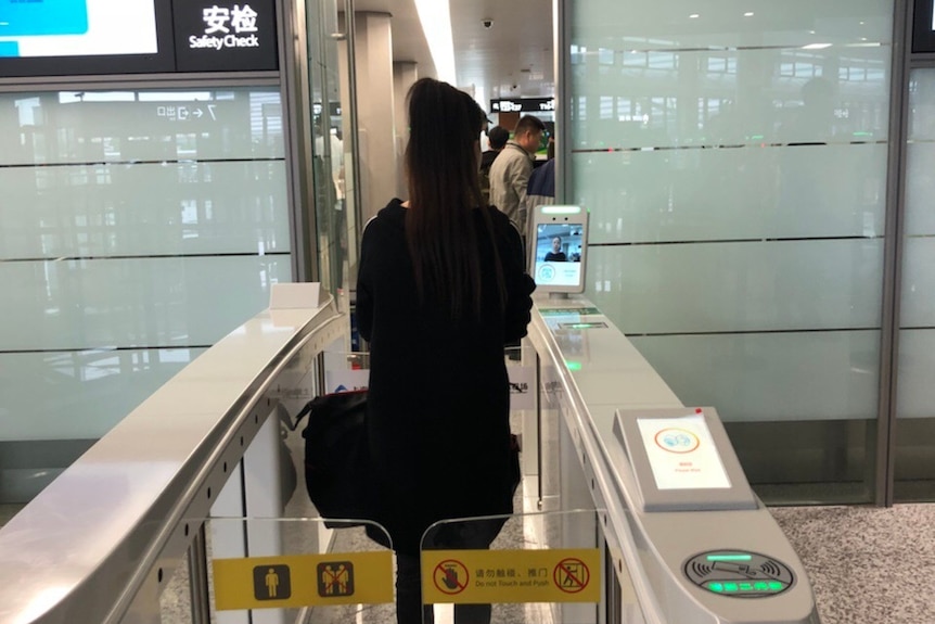 A passenger goes through the facial recognition check-in system