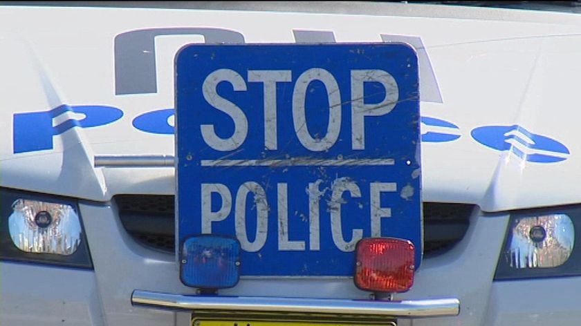 Generic - close-up TV still of 'Stop Police' sign on front of police car.