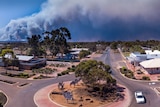 Smoke clouds from bushfires near a small town.