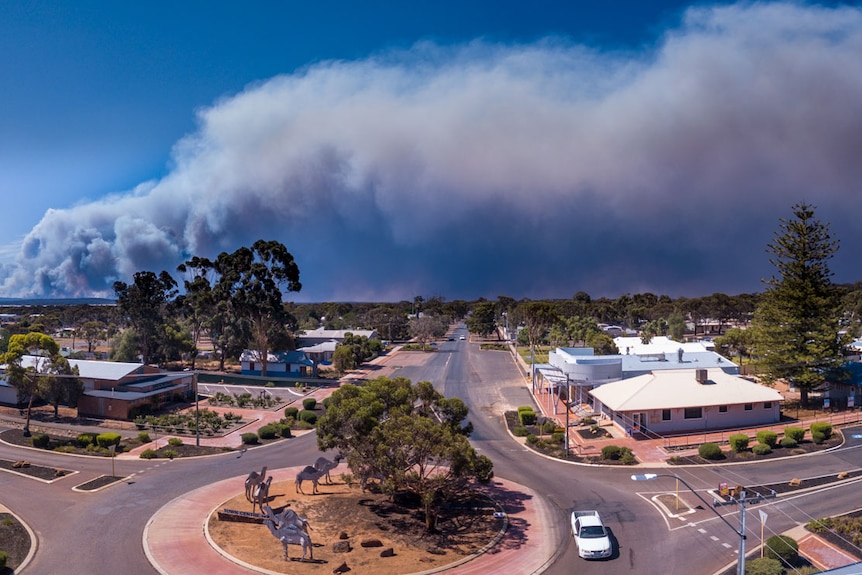 Smoke clouds from bushfires near a small town.