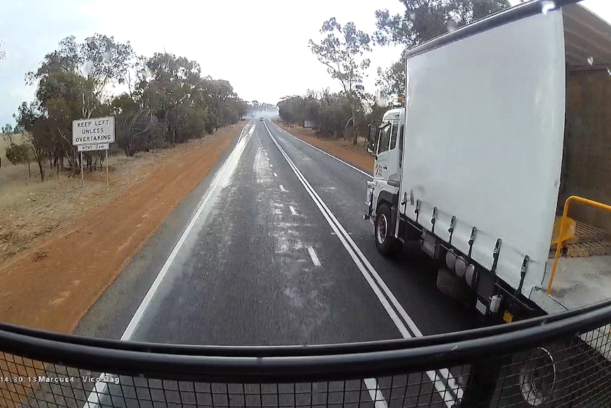 A screenshot from Murray York's dashcam of a truck overtaking across double-white lines.