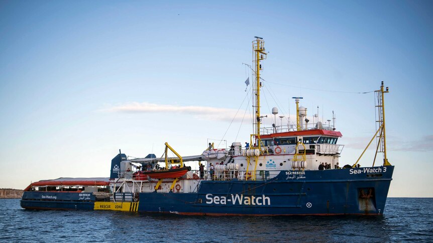 Sea-Watch rescue ship waits in the ocean far from shore.