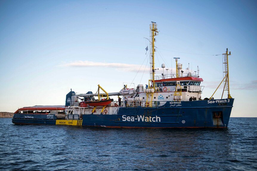 Sea-Watch rescue ship waits in the ocean far from shore.