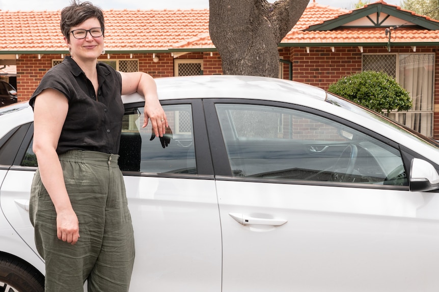 Woman standing next to white car