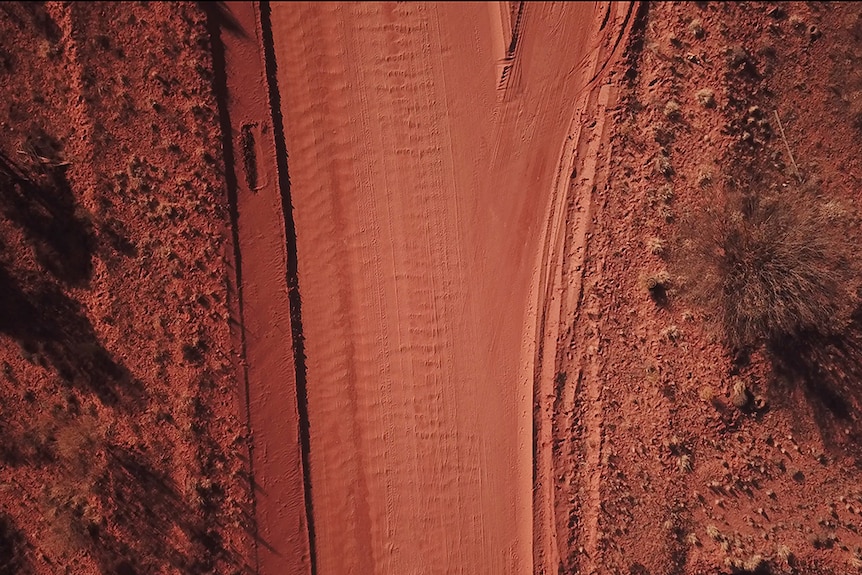 An aerial view of a red dirt desert road on the outskirts of Mimili.