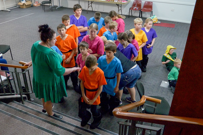 Kids in colourful costumes assemble at a set of stairs, Longreach November 2022.