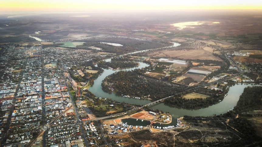 an aerial view at sunrise of the city of Mildura with the Murray River and farmland in the background