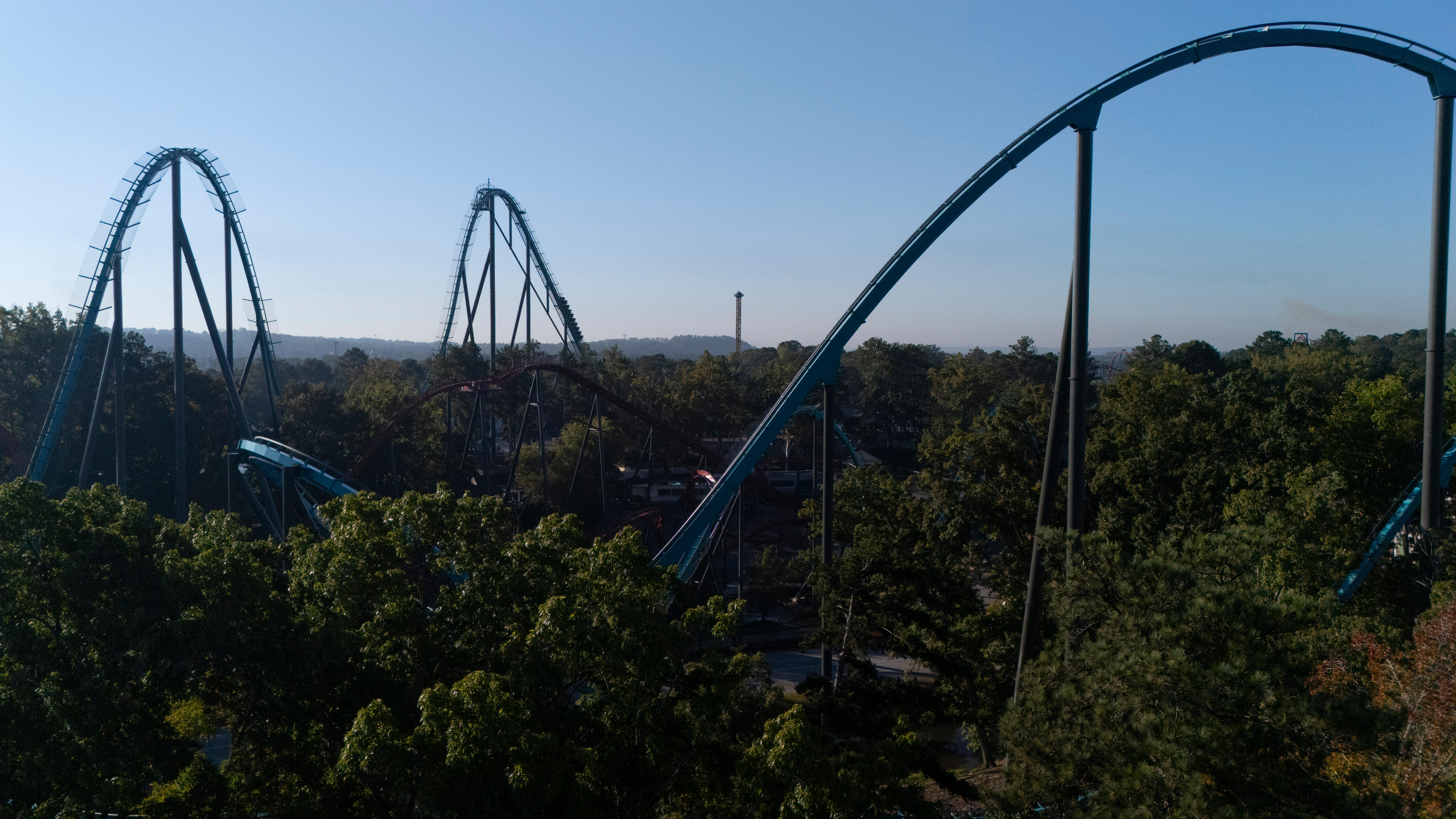 An aerial view of attractions at Six Flags over Georgia. The ground is covered in trees.