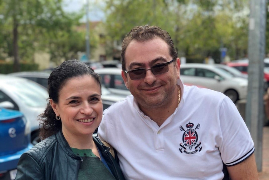 A middle aged woman and her partner look at the camera