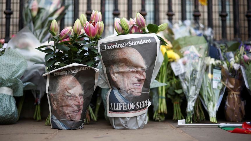 A picture of Britain's Prince Philip, husband of Queen Elizabeth, is seen in the newspapers wrapped around flowers.