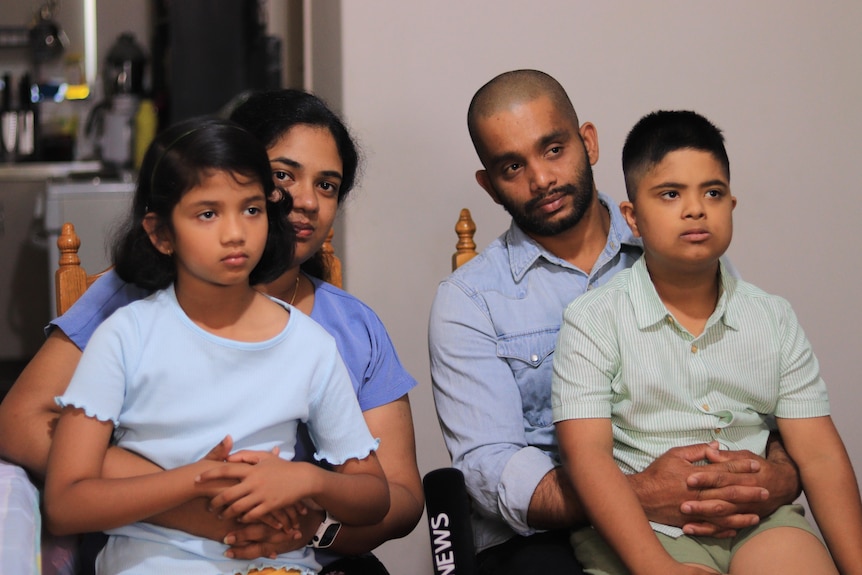 Two parents sitting with two children on their laps