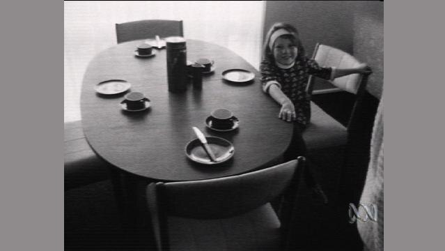 Old photo of girl sitting at dining table
