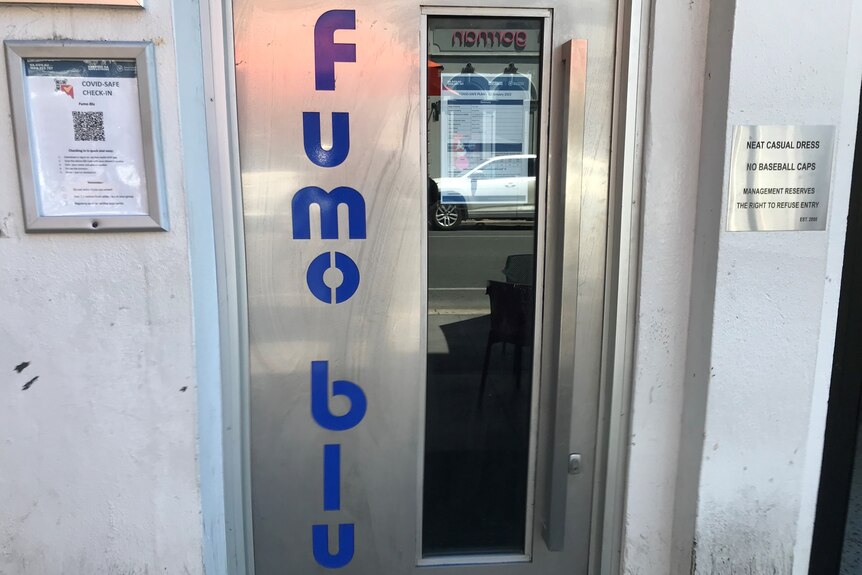 A silver door with the words 'fumo blu' written in blue writing down the side