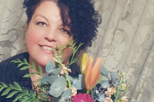 woman holding bunch of flowers smiling