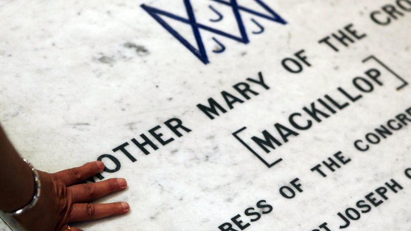 A Catholic touches the tomb of Mary MacKillop