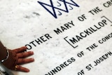 A Catholic touches the tomb of Mary MacKillop