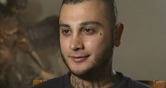 Video still of man with tattooed neck.