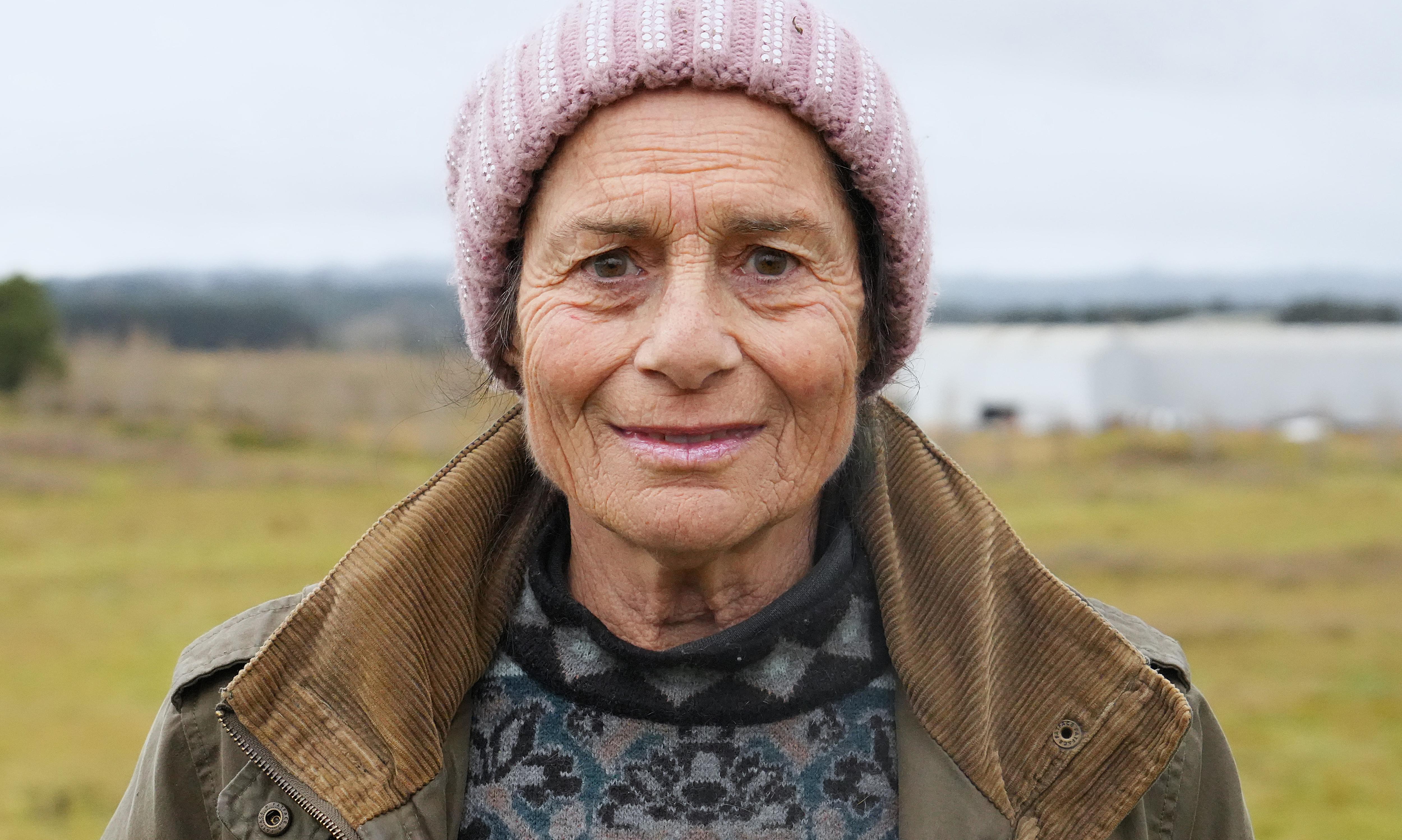 woman in beanie and jumper in close up in front of field