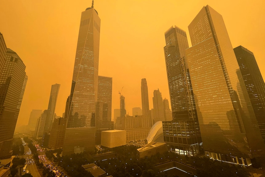 Skyscraper buildings seen amid orange haze.