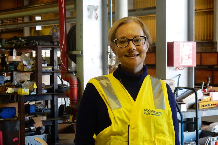 Melissa Anderson, wearing a yellow safety vest, at her new job.