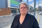 A woman with glasses standing in front of the Royal Adelaide Hospital 