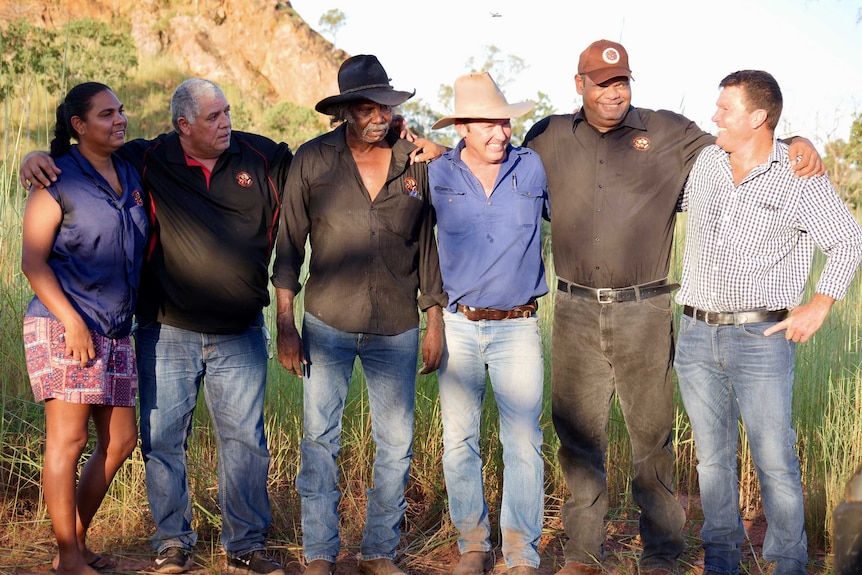 Indigenous men and women standing side by side with pastoralists in the Kimberley outback