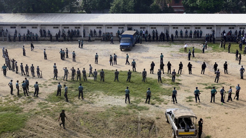 Bangladeshi police and Rapid Action Battalion members stand guard outside the specially built court.