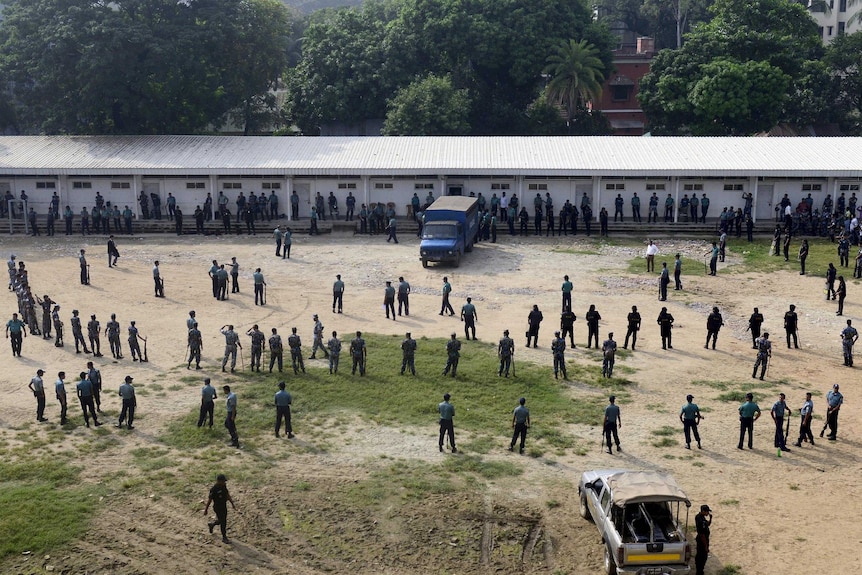 Bangladeshi police and Rapid Action Battalion members stand guard outside the specially built court.