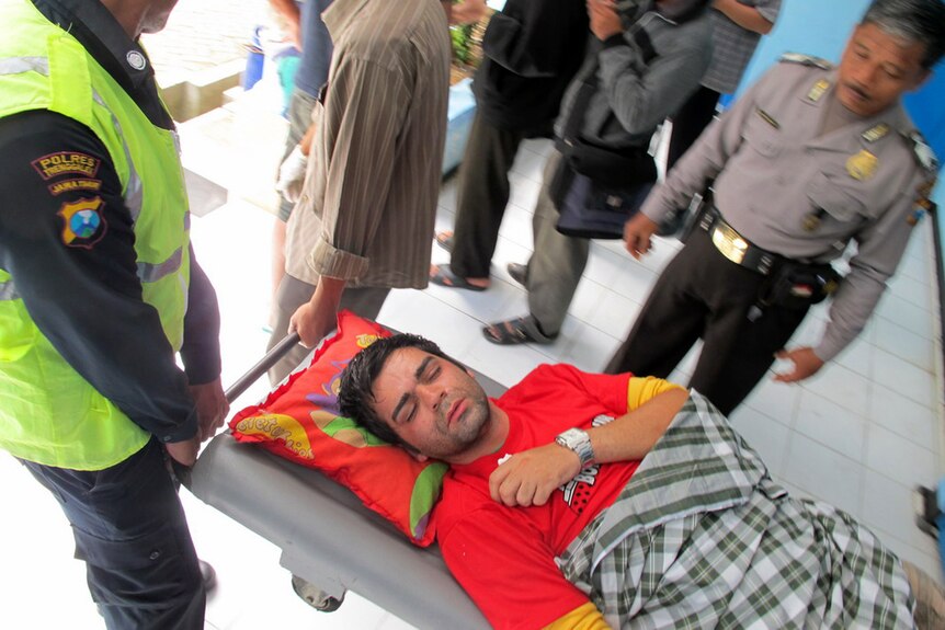 Asylum seeker is carried on a stretcher