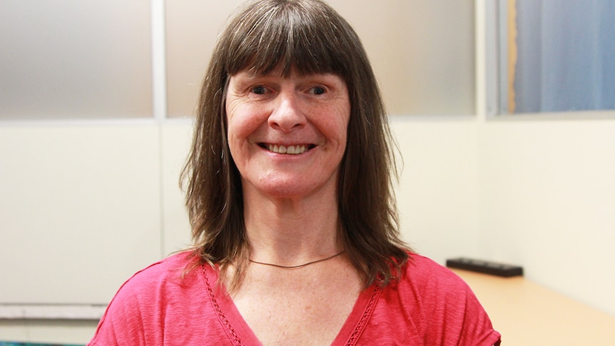 A woman with shoulder-length brown hair smiles at the camera