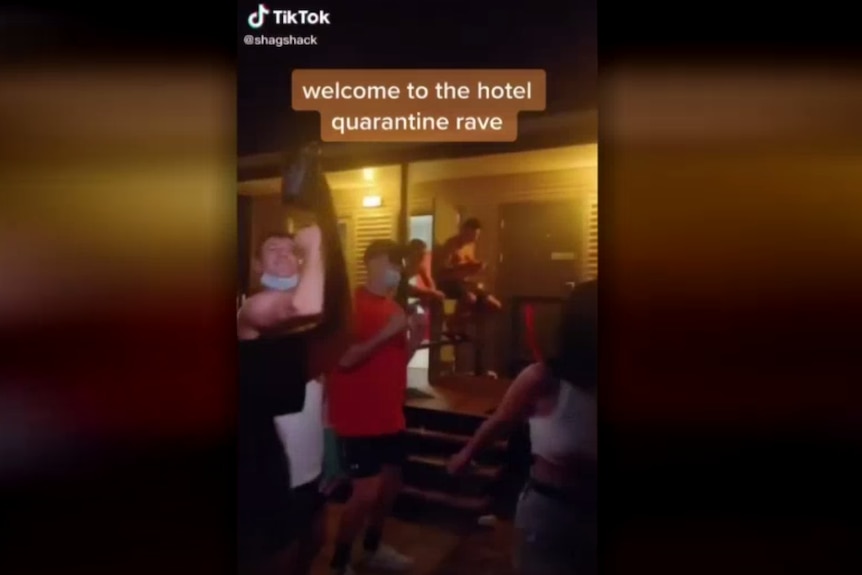 A video which shows people dancing with the words 'welcome to the hotel quarantine rave' in the background.
