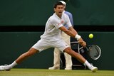 Novak Djokovic hits a winner at full stretch at Wimbledon