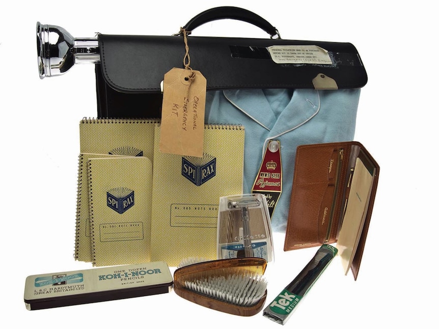 A collection of supplies including a briefcase, notepads, pencils, comb, hair brush, toothbrush, wallet and pyjamas.