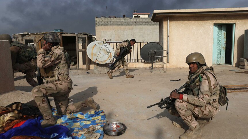 Iraqi soldiers take cover during clashes with Islamic State fighters.
