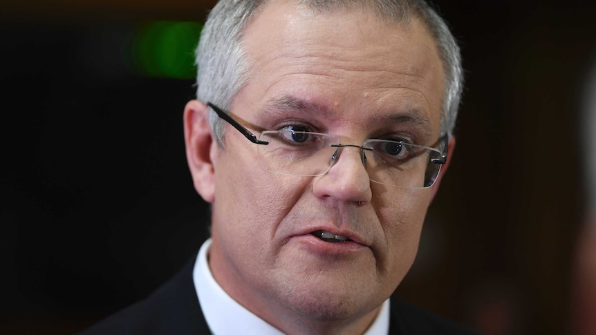 Close up of Treasurer Scott Morrison wearing glasses while speaking to journalists